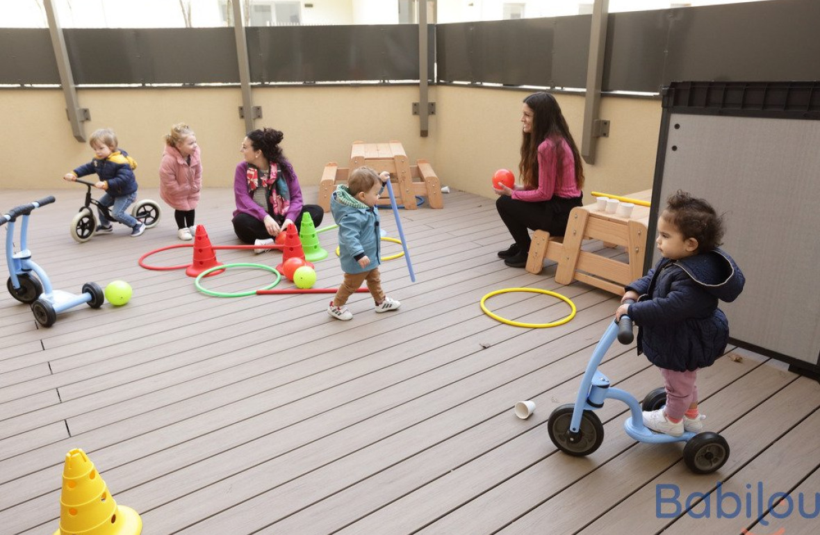 Un groupe d'enfants en crèche qui jouent en extérieur 