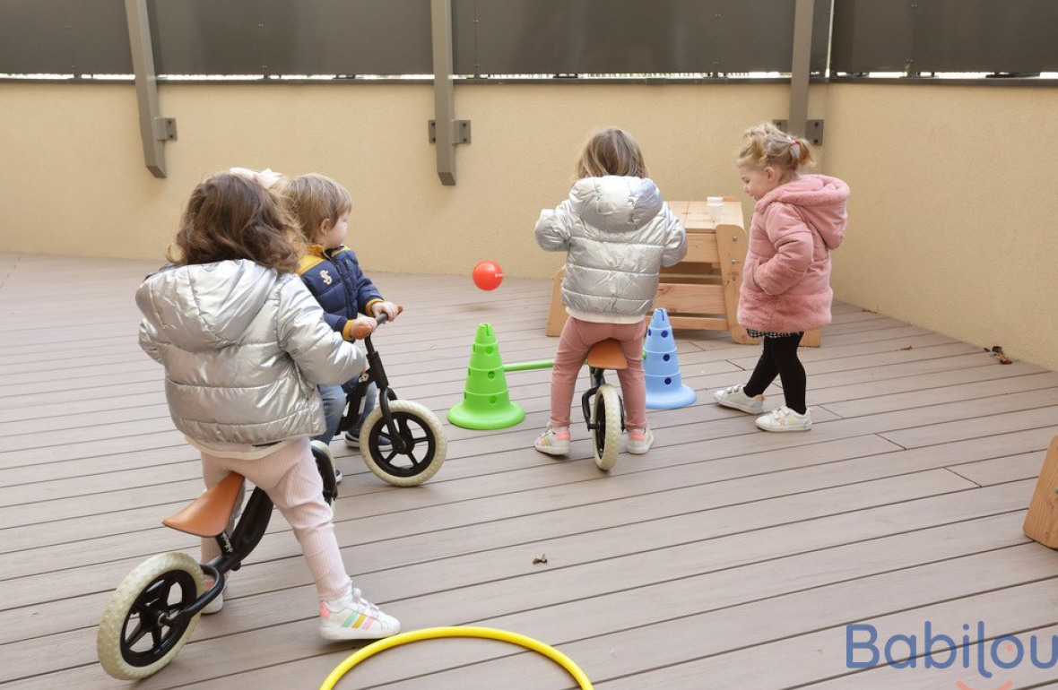 Un groupe d'enfants en crèche qui jouent en extérieur 