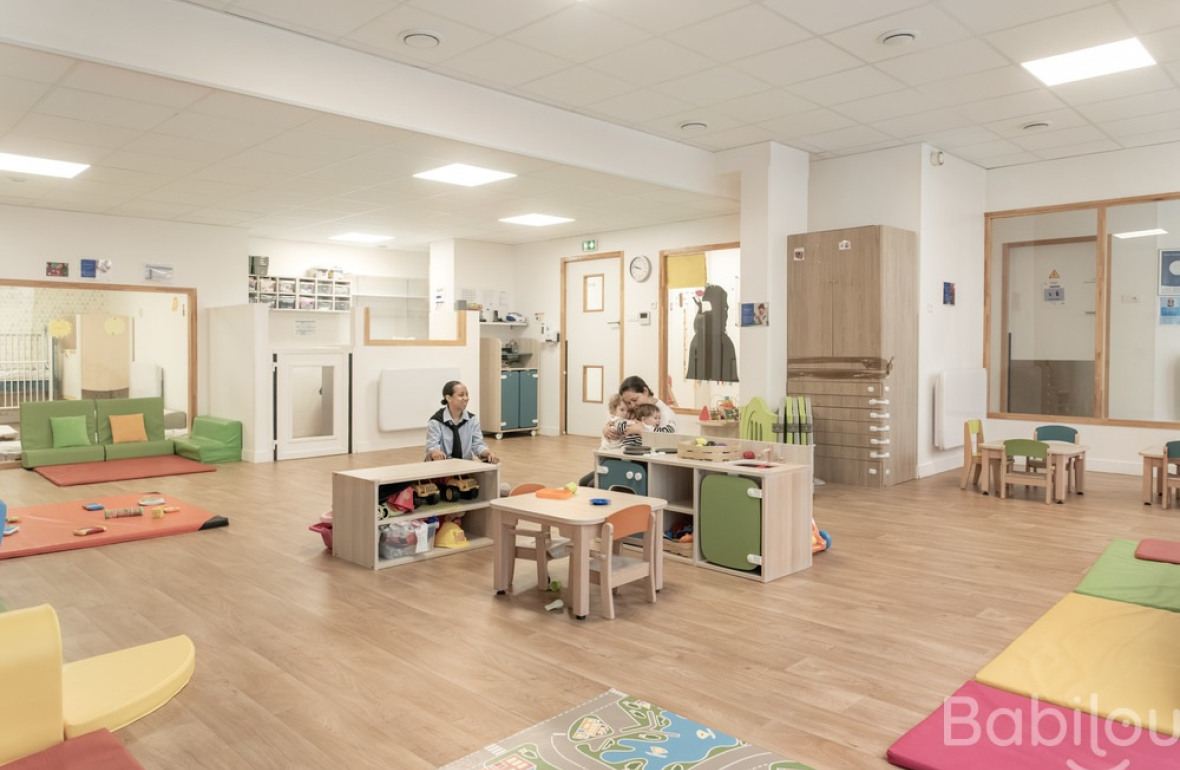 Une professionnelle en crèche en activité avec un enfant