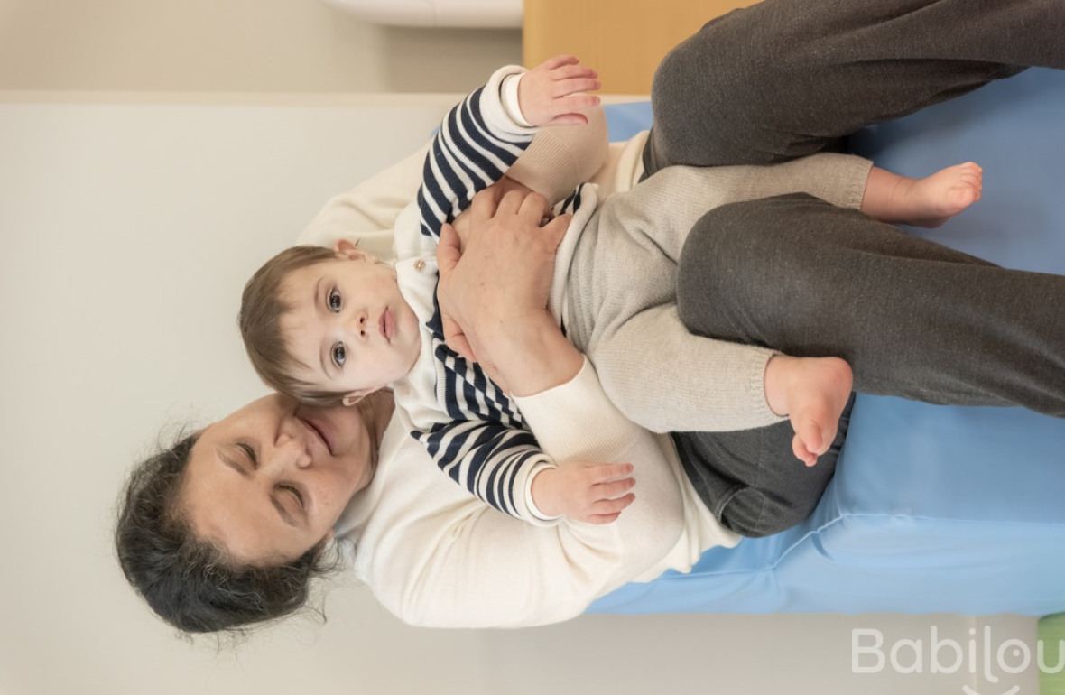 Une pro en crèche assise avec un enfant