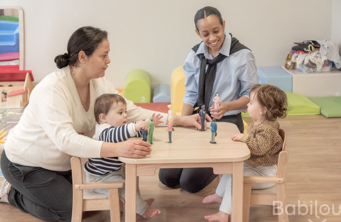 Deux pro crèche qui jouent avec deux enfants 