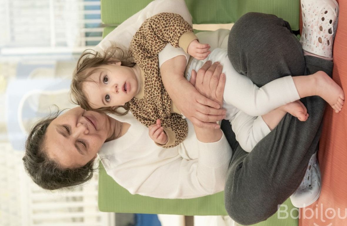 Une pro en crèche assise avec un enfant