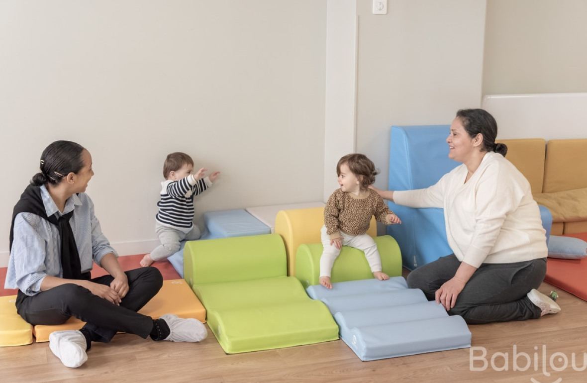 Deux pro crèche qui jouent avec deux enfants 