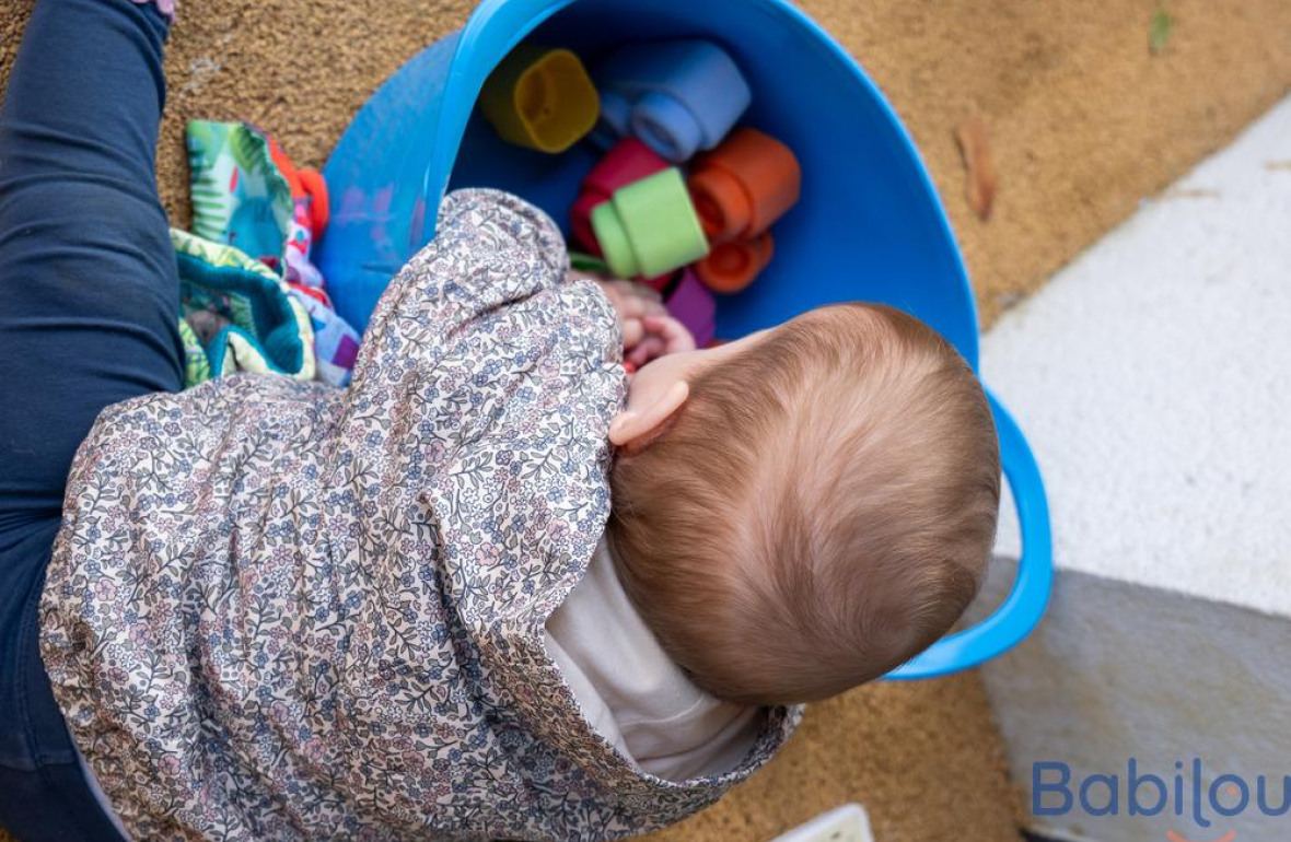 Un bébé en crèche qui joue dans le jardin