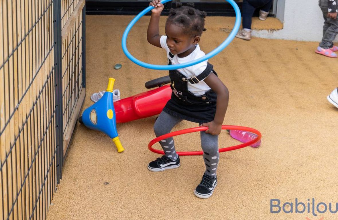 Une petite fille en crèche qui joue dans le jardin