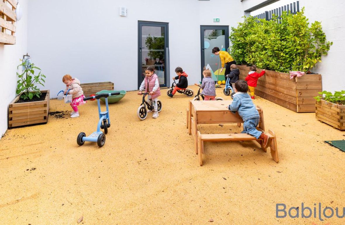 Un groupe d'enfant en crèche jouant dans le jardin