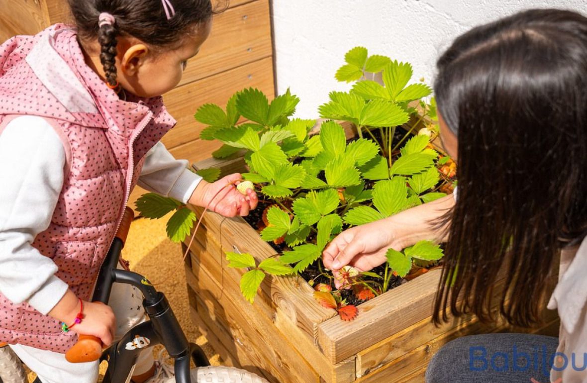 Un pro en crèche dans le jardin avec une enfant