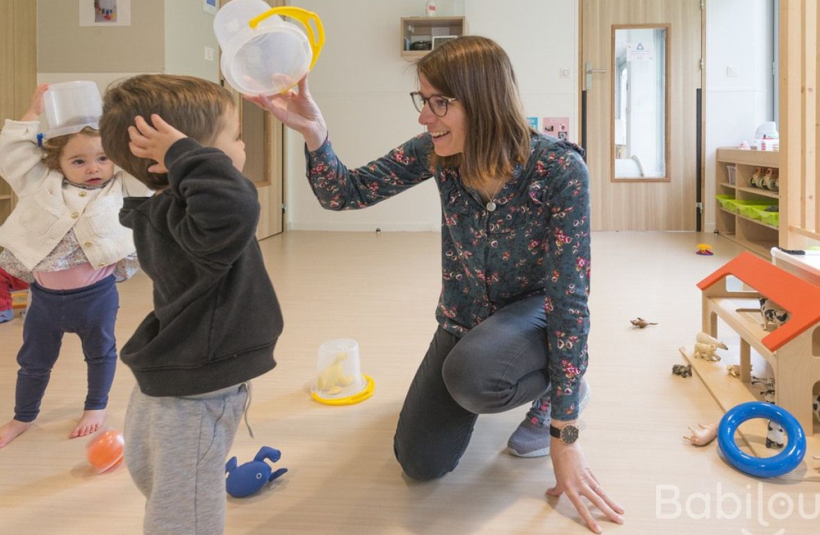 Une pro en crèche en interaction avec deux enfants