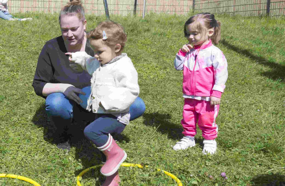 Une pro en crèche qui joue avec un groupe d'enfants