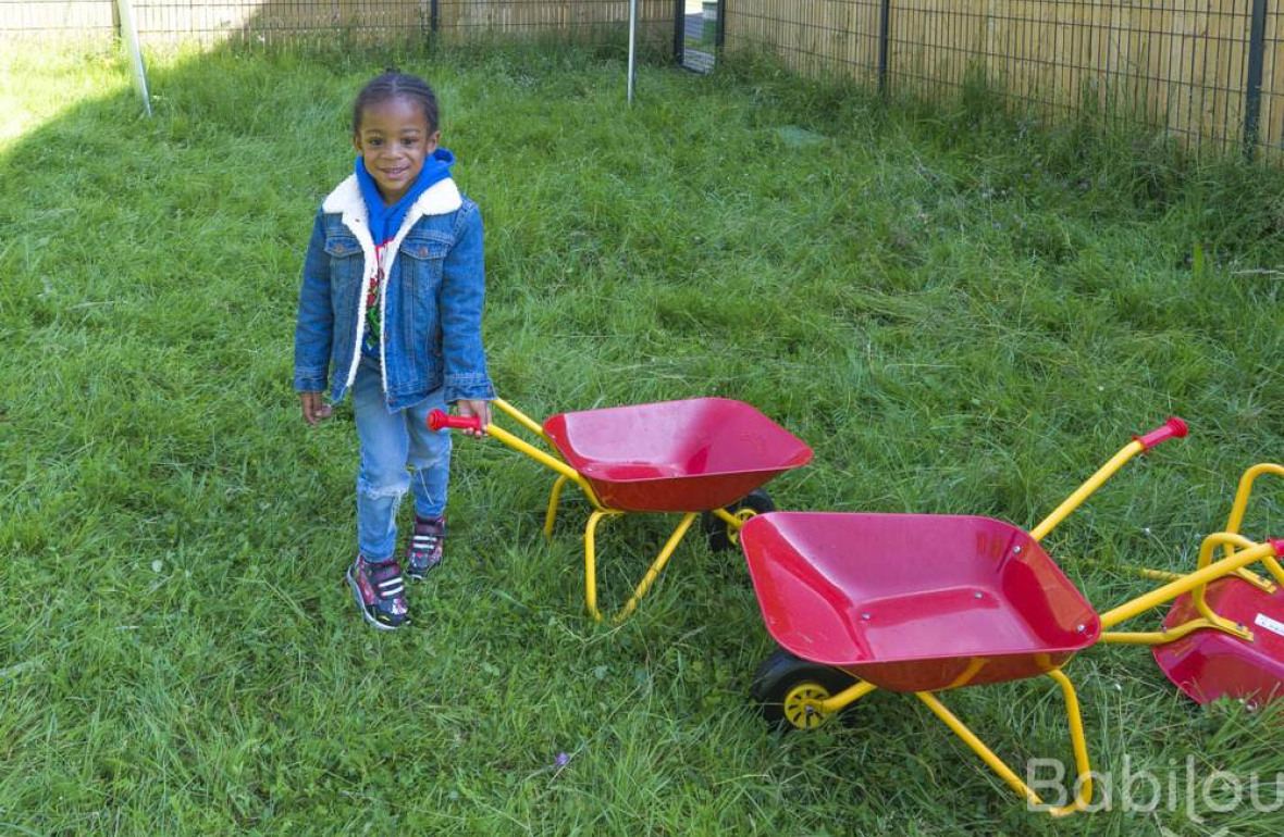 Une enfant en crèche Babilou qui joue dans le jardin