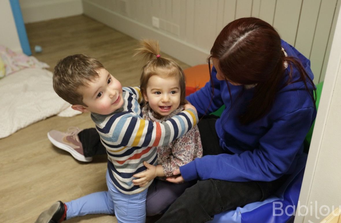 Une professionnelle en crèche Babilou avec deux enfants