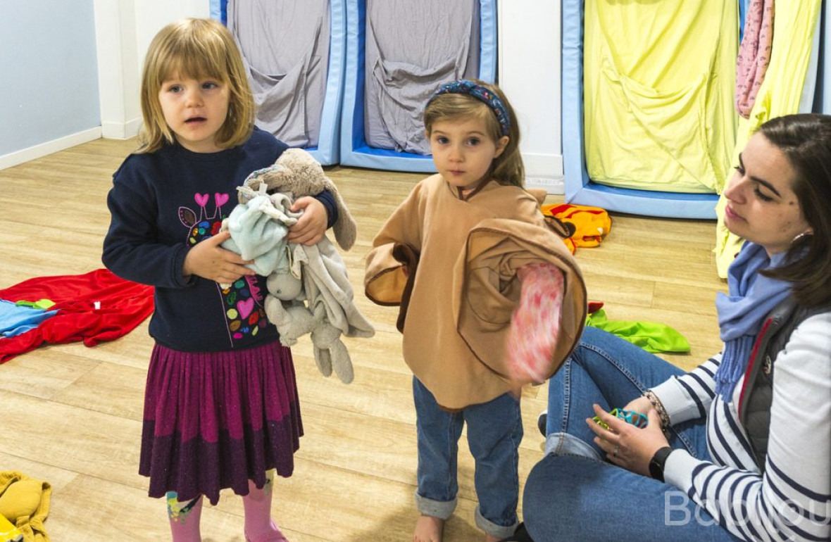 Une pro et deux enfants en crèche en interaction 