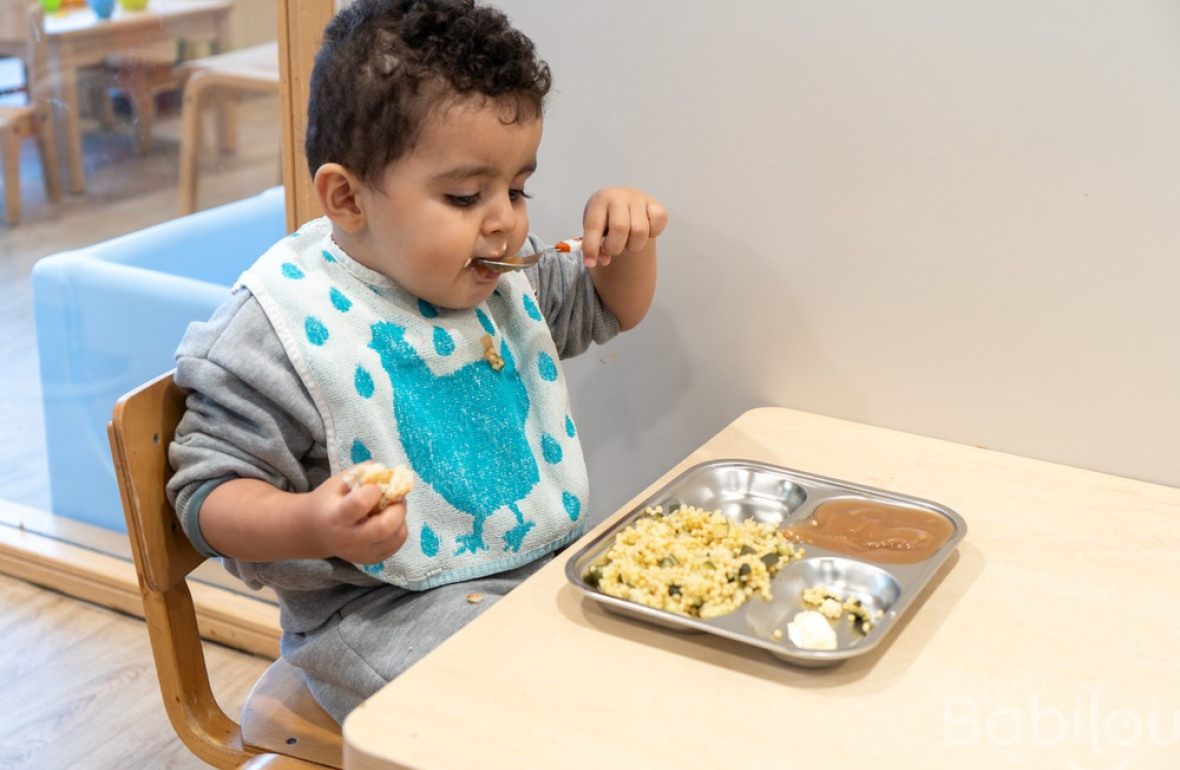 Un enfant en crèche Babilou qui mange