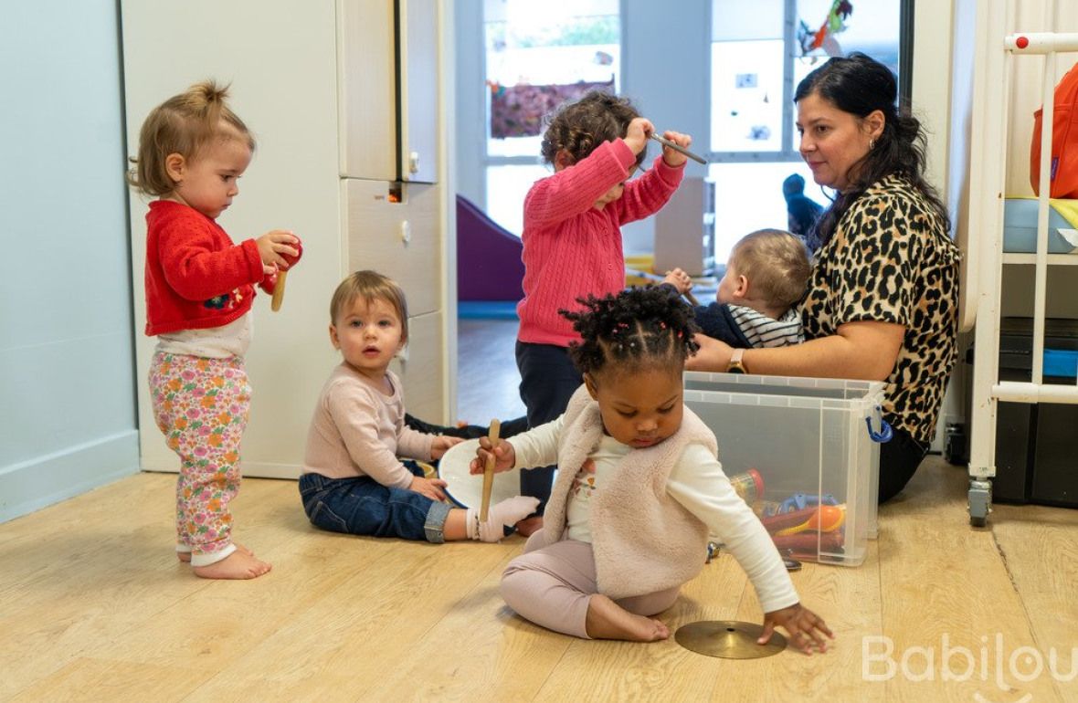 Une pro en crèche jouant avec un groupe d'enfants