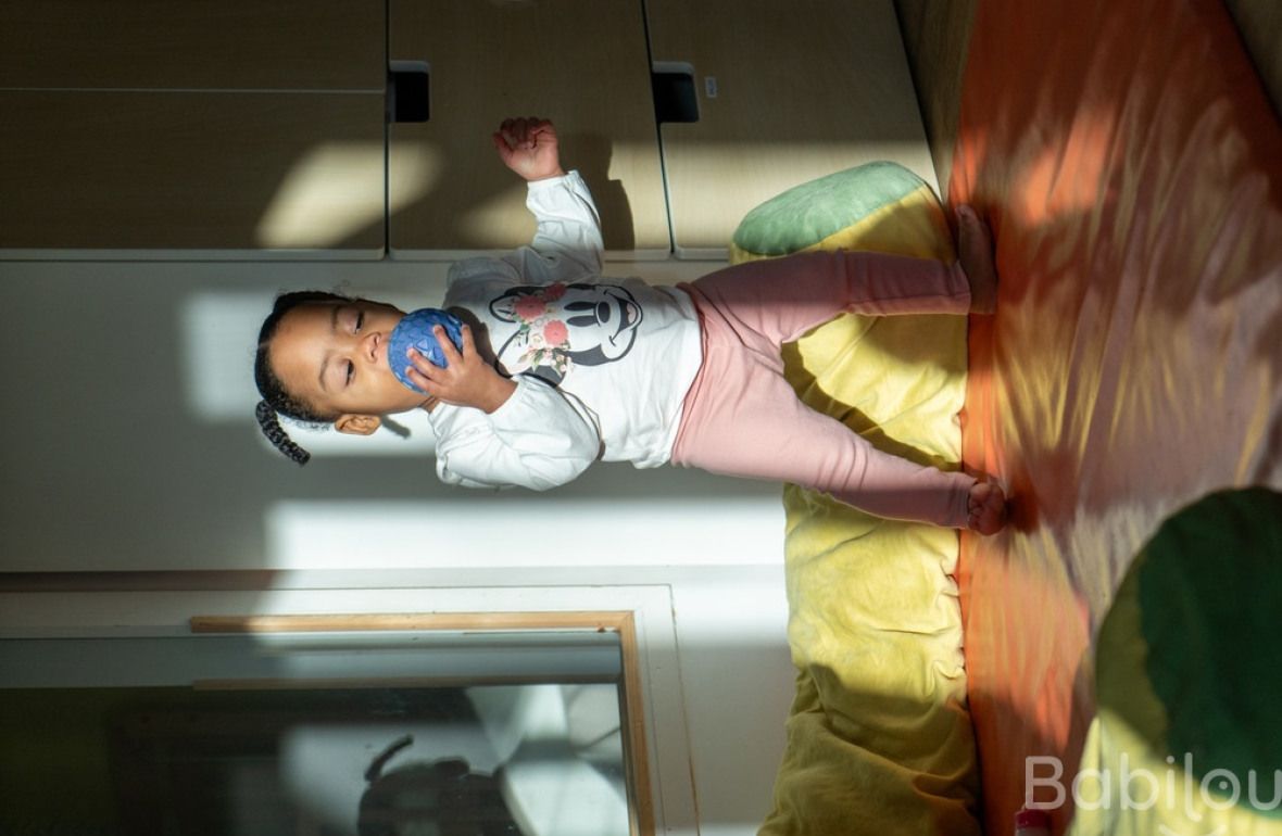 Une enfant en crèche debout