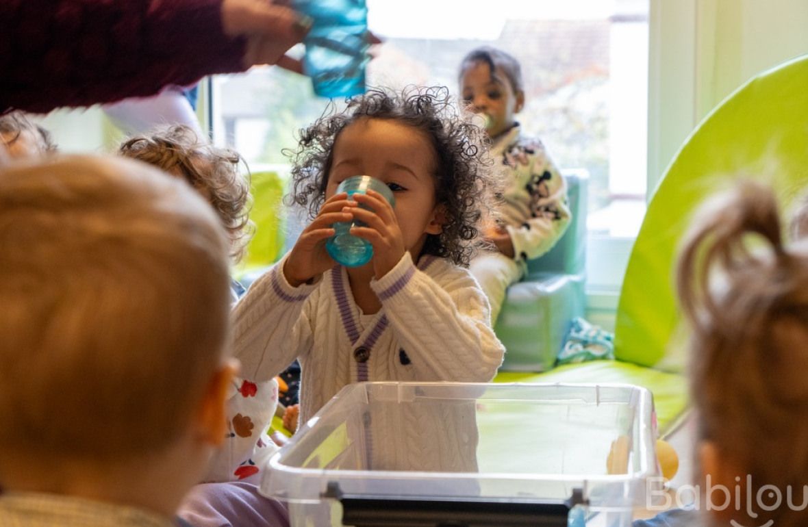 Une enfant en crèche Babilou qui boit 