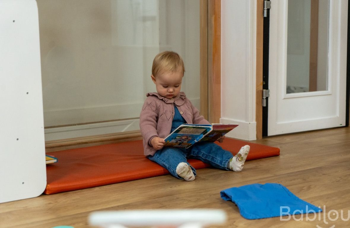 Une enfant en crèche qui lit