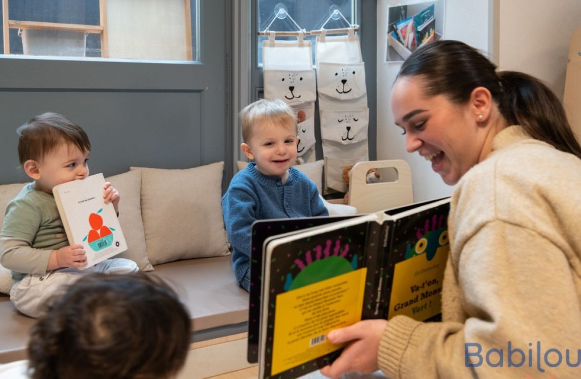 Une pro en crèche qui lit un livre à un groupe d'enfants