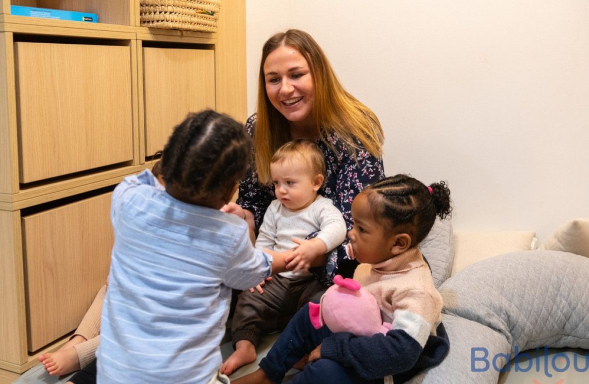 Une pro en crèche jouant avec trois enfants 