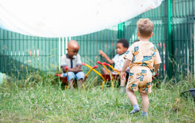 Trois enfants en train de jouer dans le jardin d'une crèche Babilou