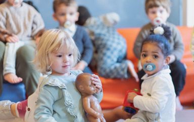 Deux petites filles jouant avec un groupe d'enfant au sein d'une crèche Babilou.