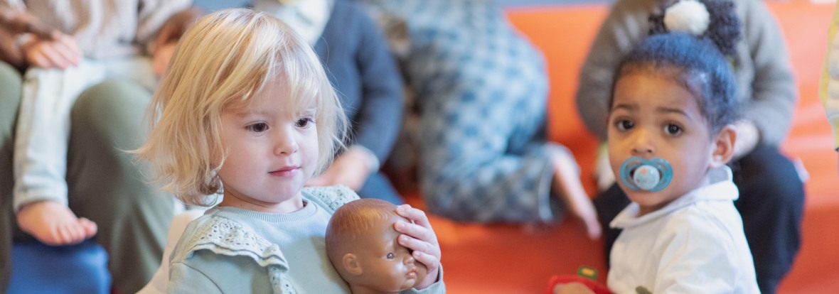 Deux petites filles jouant avec un groupe d'enfant au sein d'une crèche Babilou.