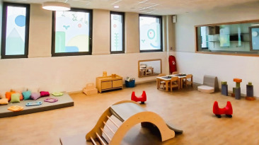 Vue large et lumineuse de la salle d'éveil au sein de la crèche Babilou Nogent Sémard