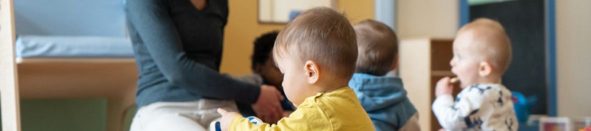 Une pro en crèche en interaction avec un groupe d'enfants