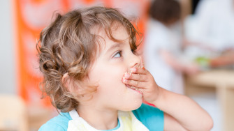 Enfant qui met sa main à la bouche